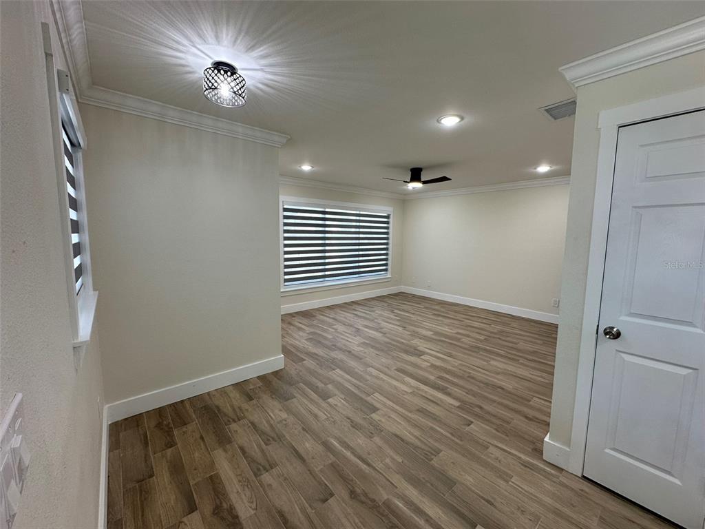 6013 Fortune Place, Unit 6013 Apollo Beach, FL 33572 - Photo 8 of 38 a view of empty room with wooden floor and fan