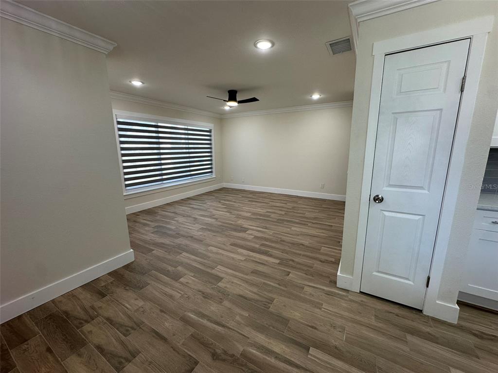 6013 Fortune Place, Unit 6013 Apollo Beach, FL 33572 - Photo 9 of 38 an empty room with wooden floor and windows