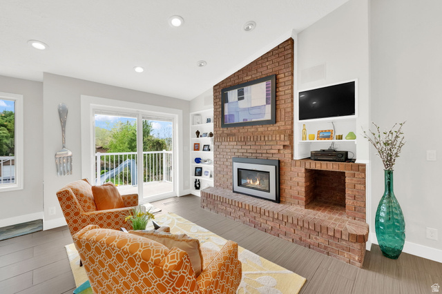 1506 Lakeview Drive Bountiful, UT 84010 - Photo 14 of 58 Living room featuring lofted ceiling, a brick fireplace, light wood-style flooring, recessed lighting, and built in features