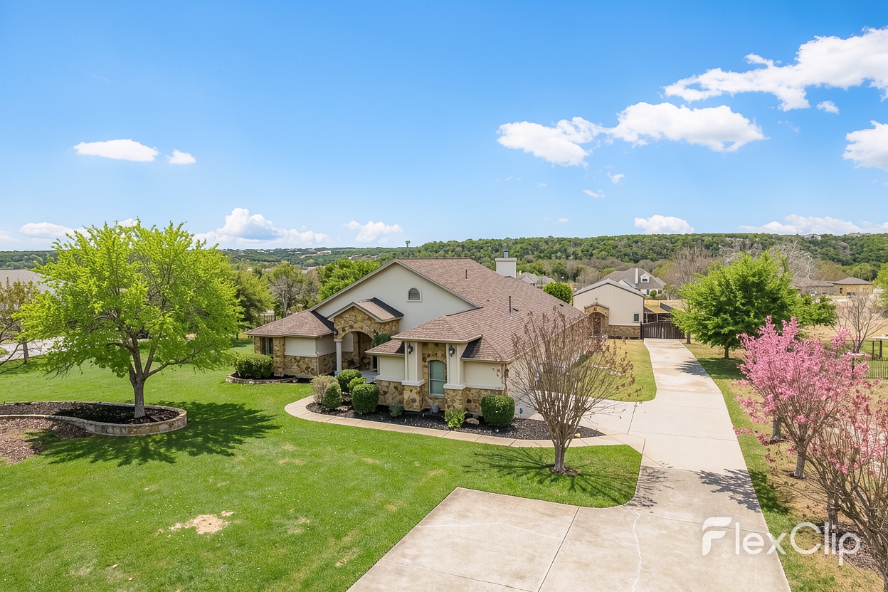 117 View Drive Georgetown, TX 78628 - Photo 1 of 40 SPRING! The property features a stone and stucco exterior, a large front lawn with mature trees, and an extended concrete driveway