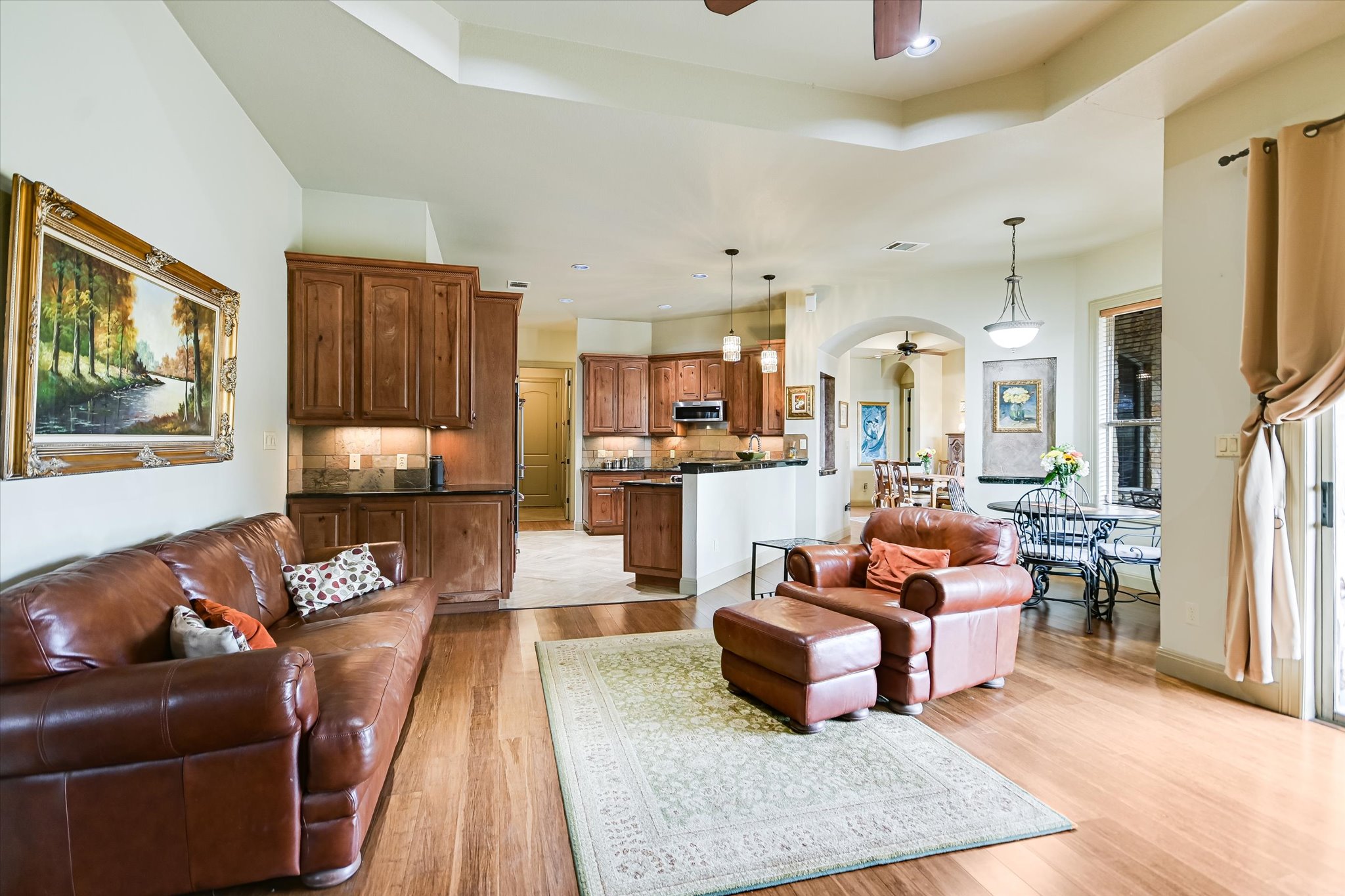 117 View Drive Georgetown, TX 78628 - Photo 14 of 40 Family area with ceiling fan, light wood finished floors, a raised ceiling, and recessed lighting open to kitchen.