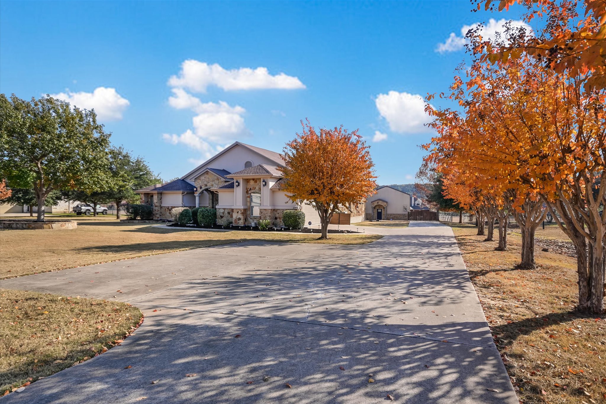 117 View Drive Georgetown, TX 78628 - Photo 2 of 40 FALL COLOR! View of front facade featuring stone & stucco siding and plentiful parking. Year ‘round color in landscape!