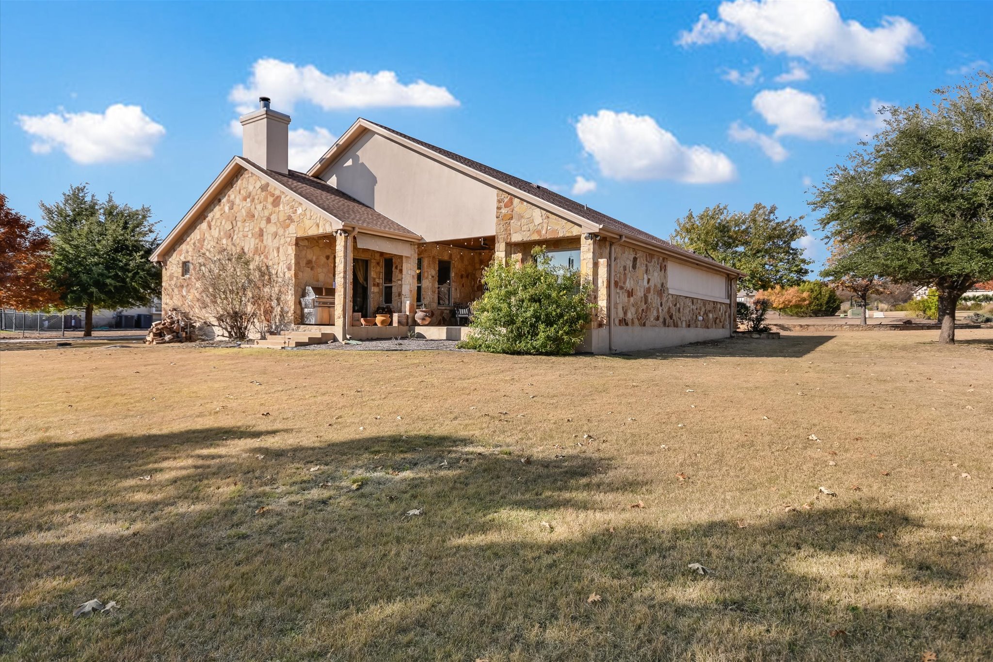 117 View Drive Georgetown, TX 78628 - Photo 26 of 40 Back of property with stone and stucco siding, a yard big enough for a pool, a large covered patio.
