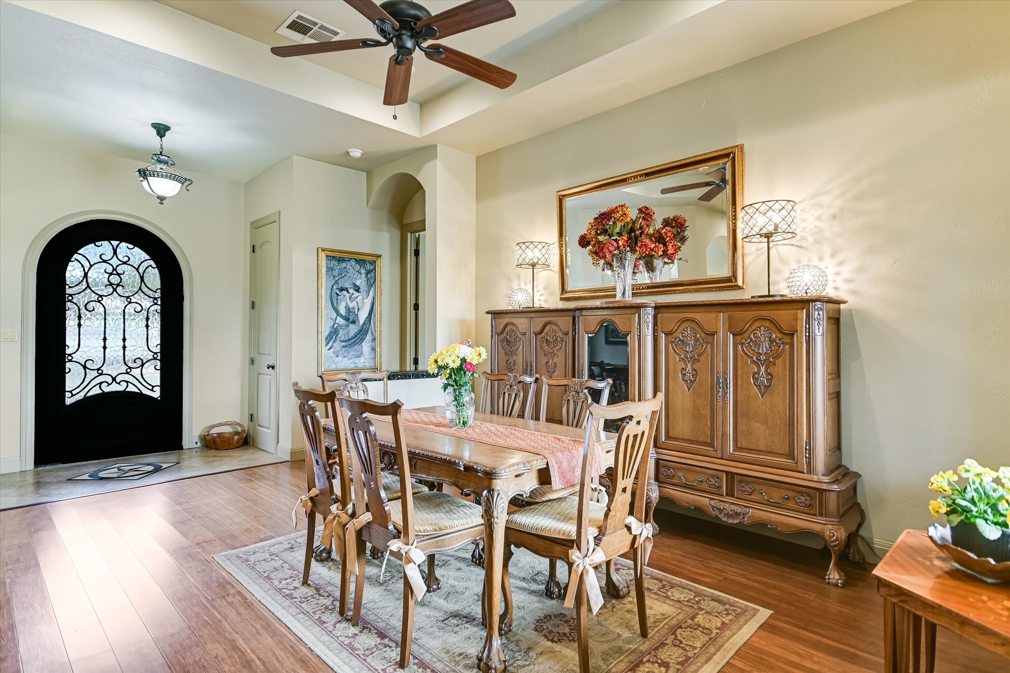 117 View Drive Georgetown, TX 78628 - Photo 6 of 40 Dining area with arched walkways, a ceiling fan, wood floors, and a raised ceiling. Stately Cantera front door.
