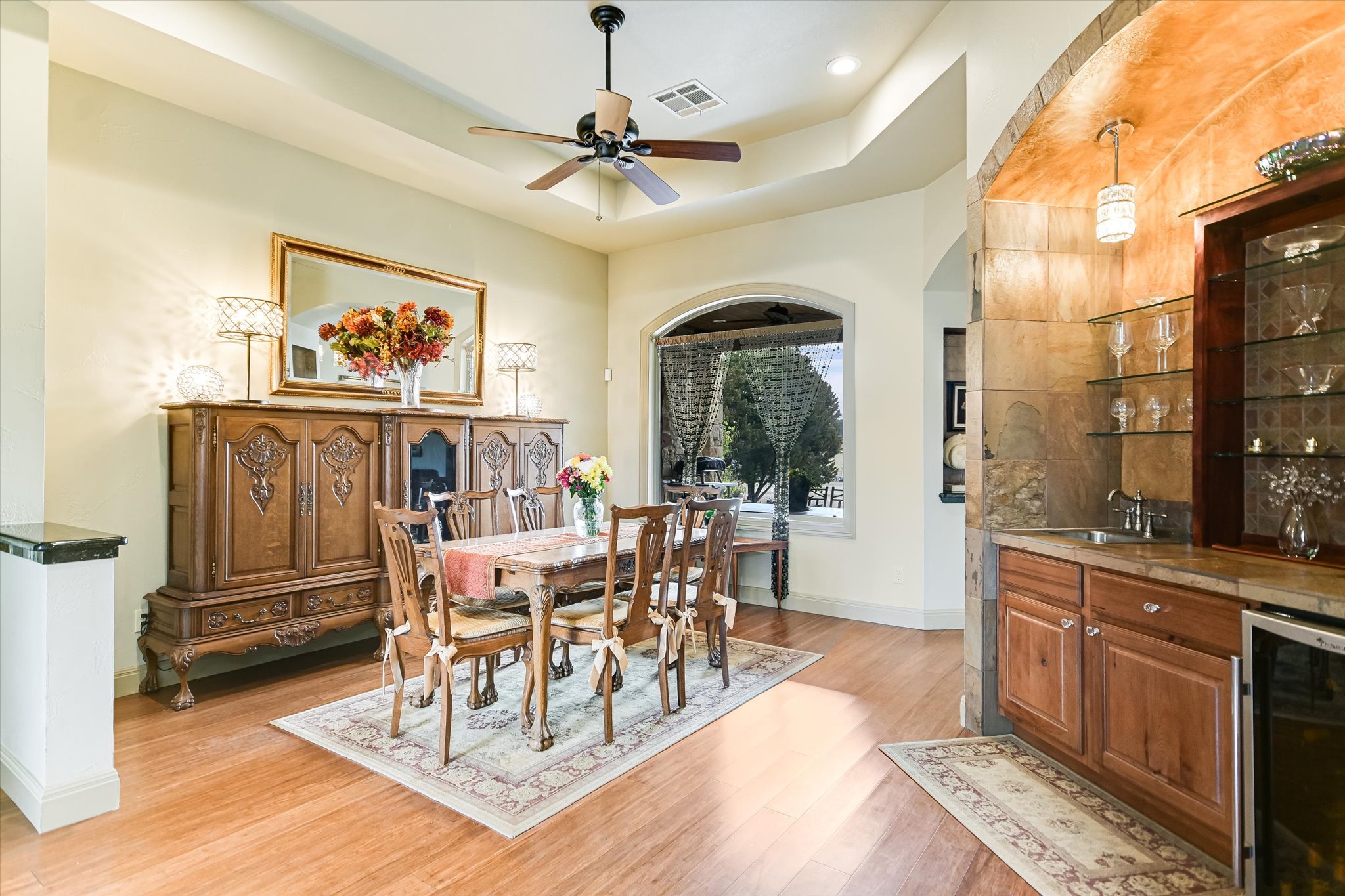 117 View Drive Georgetown, TX 78628 - Photo 7 of 40 Dining area with beverage cooler, a raised ceiling, ceiling fan, light wood flooring, and wet bar. Views toward backyard, distant plateau, and covered patio.