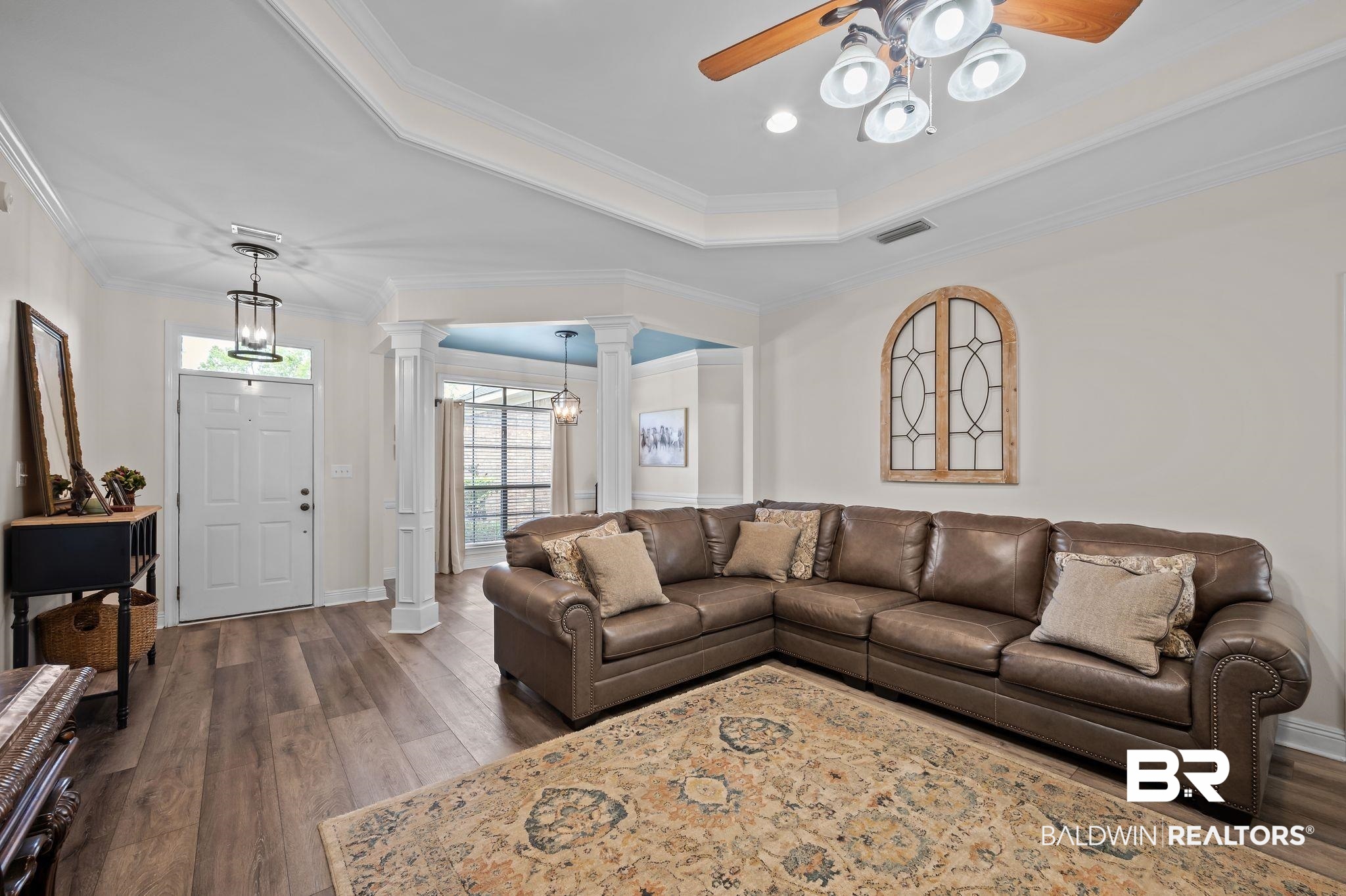 9837 Harmony Ridge Drive Semmes, AL 36575 - Photo 10 of 29 Living room with dark wood-type flooring, ceiling fan, visible vents, and decorative columns