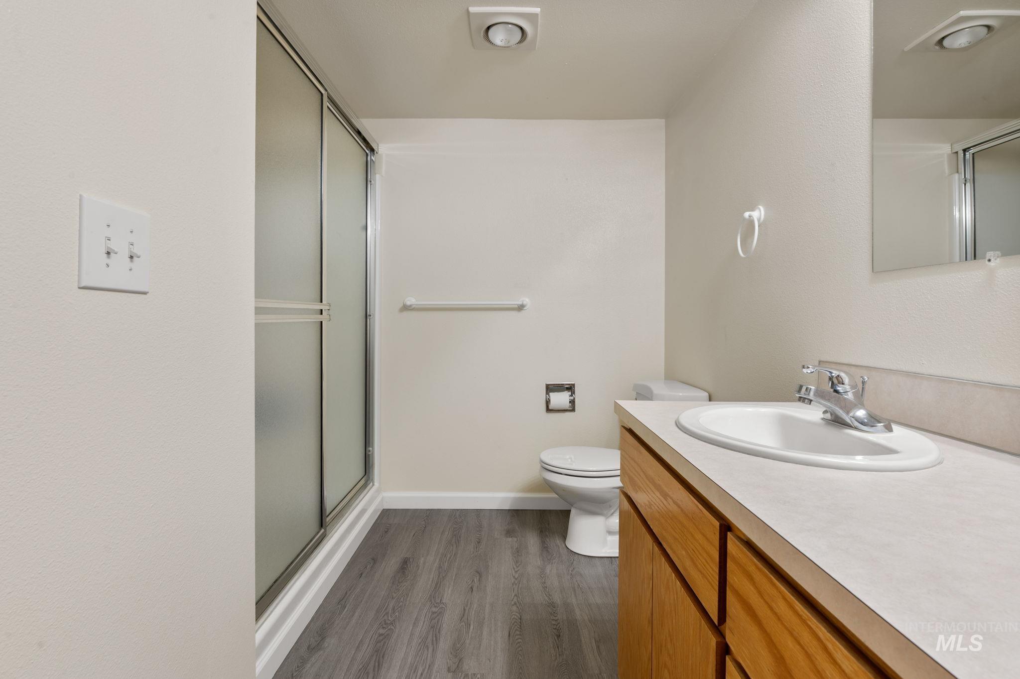 824 15th Avenue Lewiston, ID 83501 - Photo 30 of 37 Full bath featuring a stall shower, vanity, and wood finished floors