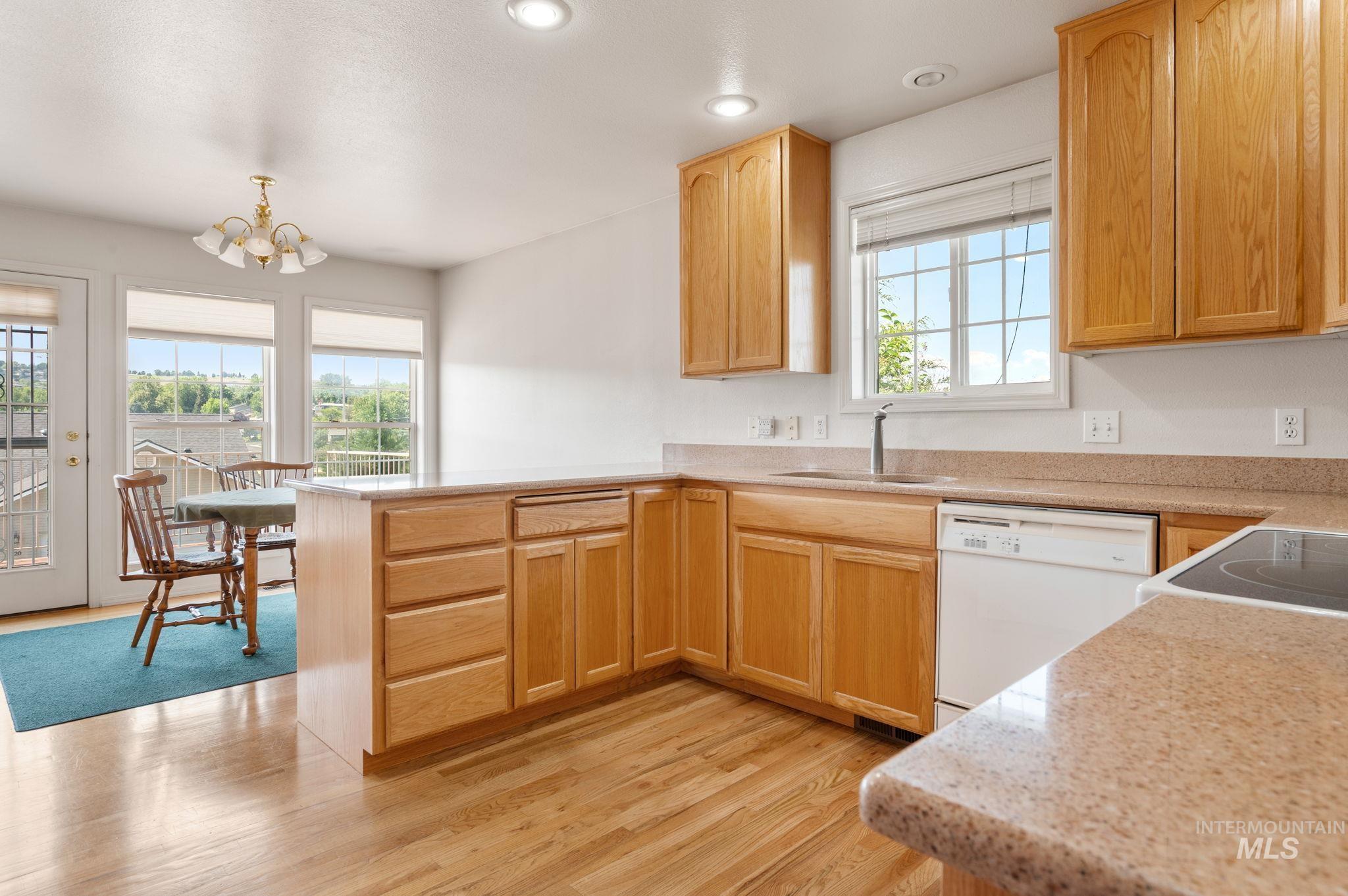 824 15th Avenue Lewiston, ID 83501 - Photo 9 of 37 Kitchen with white appliances, healthy amount of natural light, a peninsula, a chandelier, and recessed lighting
