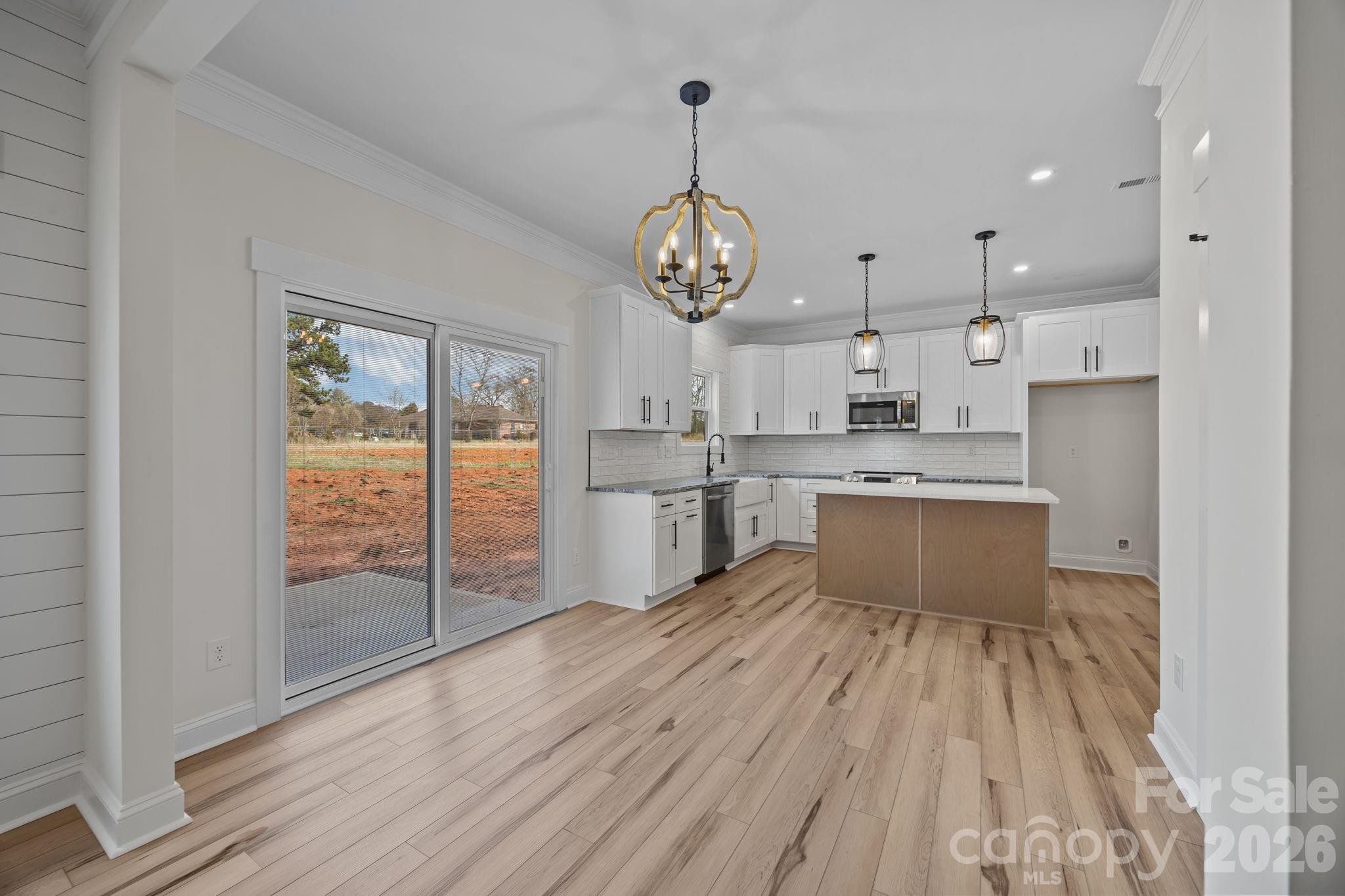 1050 Gibson Road Salisbury, NC 28147 - Photo 19 of 47 a large white kitchen with wooden floor and stainless steel appliances