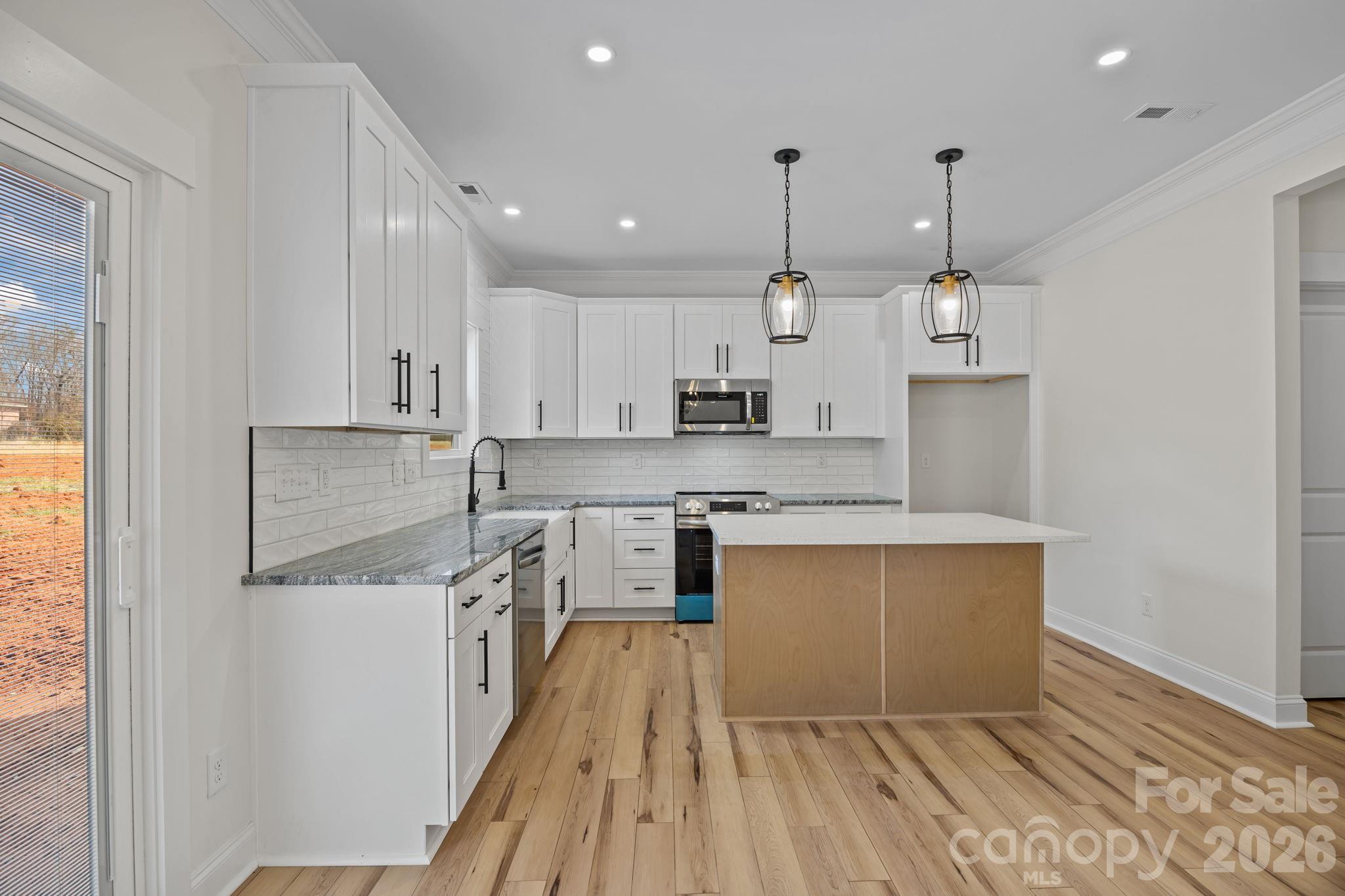 1050 Gibson Road Salisbury, NC 28147 - Photo 20 of 47 a large kitchen with stainless steel appliances granite countertop a lot of counter space and wooden floors