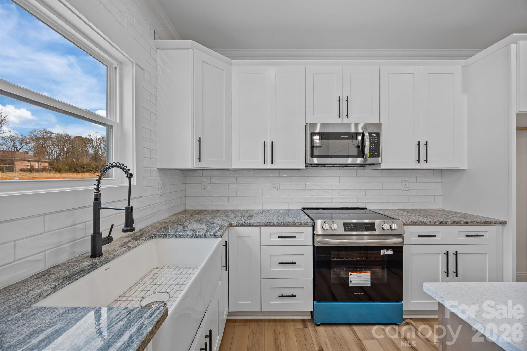 1050 Gibson Road Salisbury, NC 28147 - Photo 23 of 47 a kitchen with granite countertop a stove and a sink