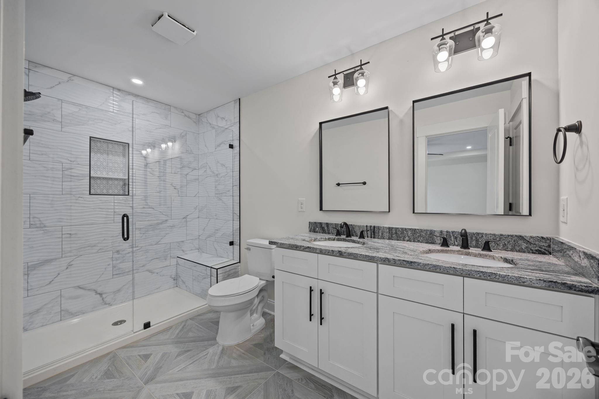 1050 Gibson Road Salisbury, NC 28147 - Photo 31 of 47 a bathroom with a double vanity sink toilet and shower