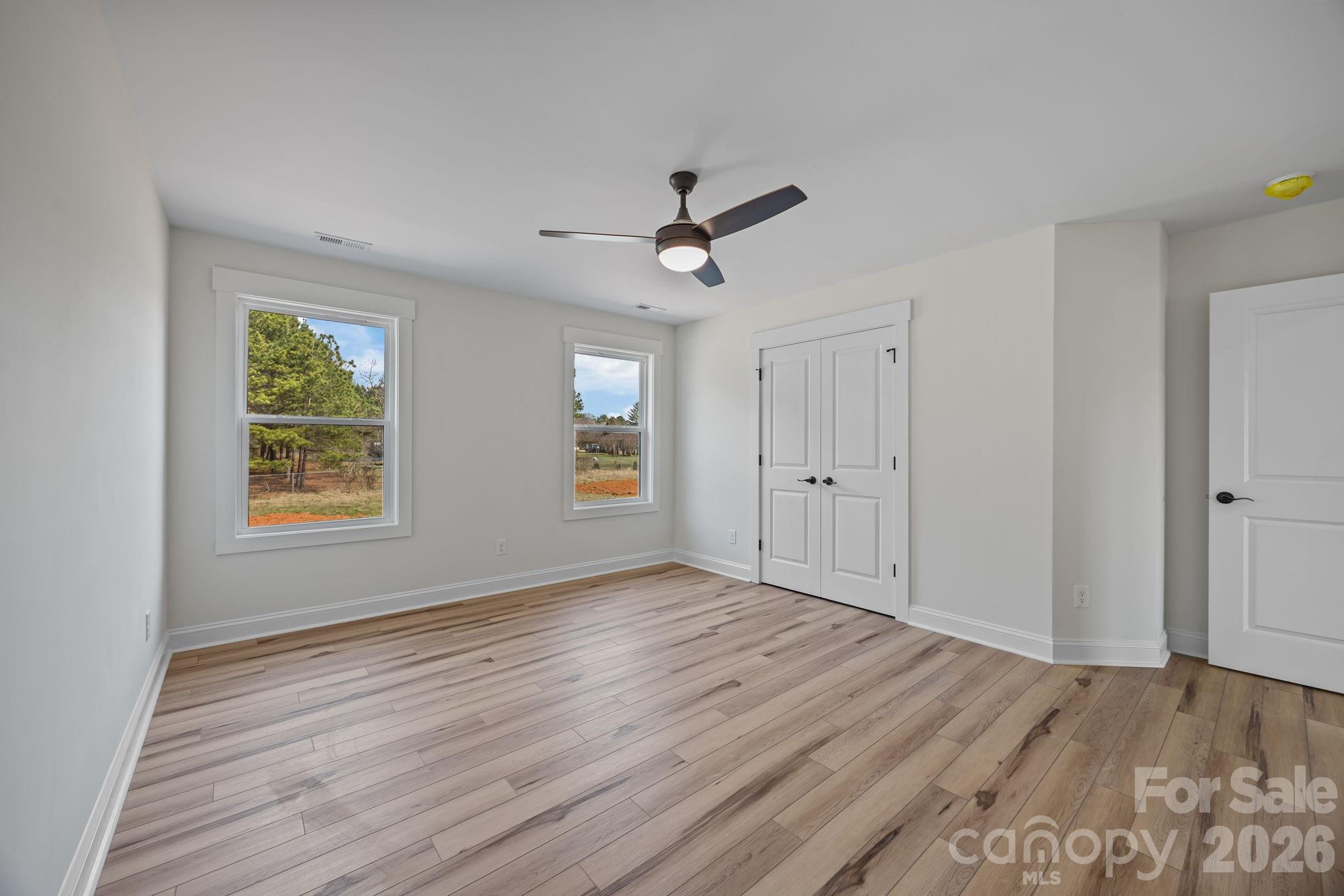 1050 Gibson Road Salisbury, NC 28147 - Photo 36 of 47 an empty room with wooden floor ceiling fan and windows
