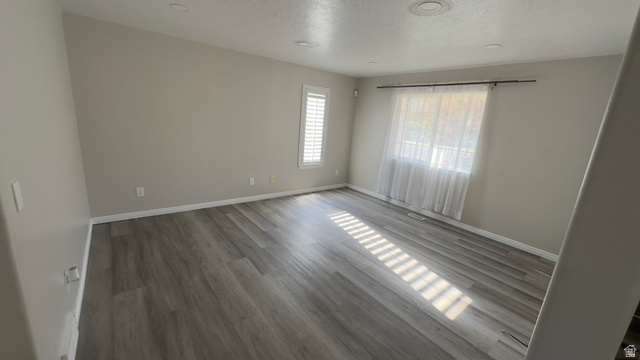 3547 East Golden Eagle Road Eagle Mountain, UT 84005 - Photo 10 of 47 Unfurnished room featuring wood finished floors and a textured ceiling