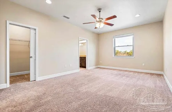 an empty room with windows and fan