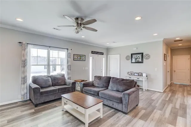 a living room with furniture flat screen tv and a window