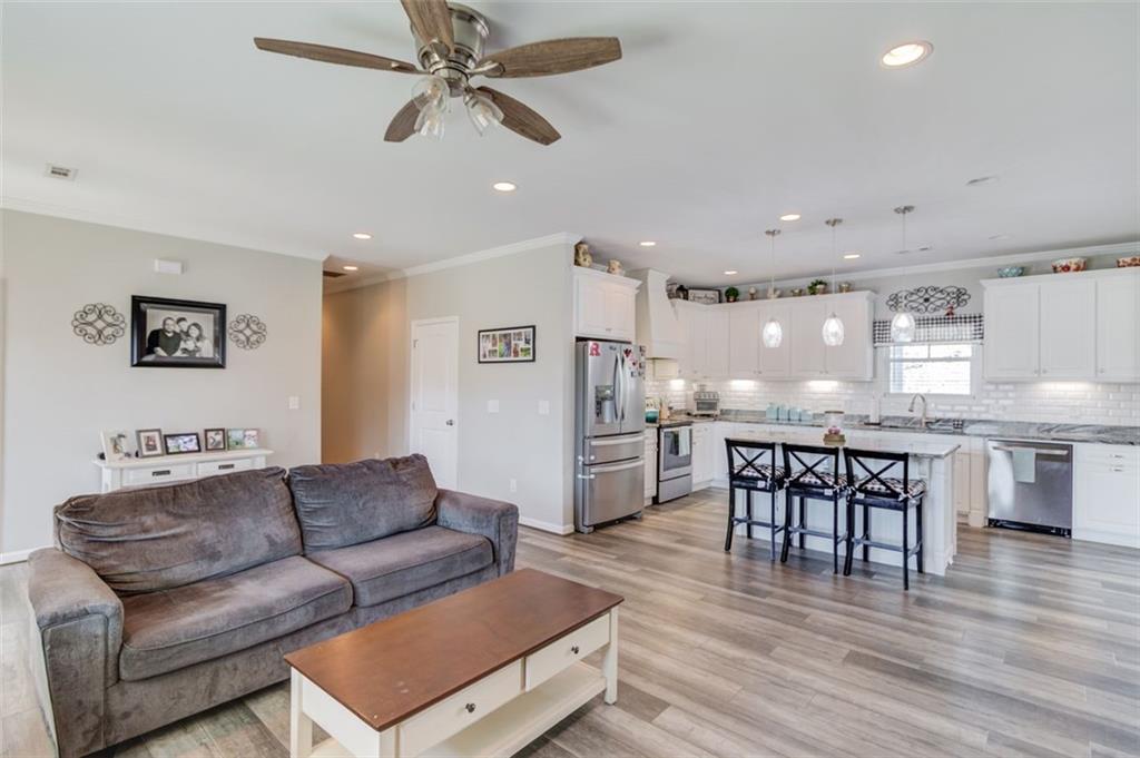 4404 Tanners Mill Road Braselton, GA 30517 - Photo 26 of 76 a living room with furniture and kitchen view