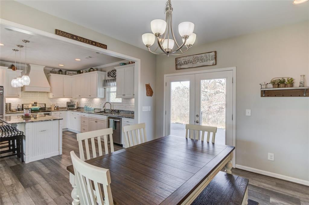 4404 Tanners Mill Road Braselton, GA 30517 - Photo 31 of 76 a view of a dining room with furniture a chandelier and wooden floor