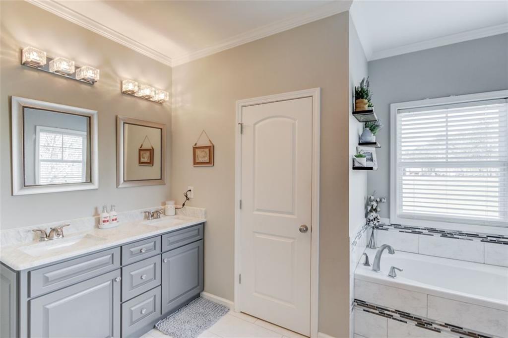 4404 Tanners Mill Road Braselton, GA 30517 - Photo 33 of 76 a spacious bathroom with a double vanity sink a mirror and a bathtub