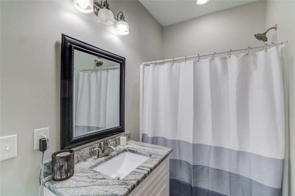 4404 Tanners Mill Road Braselton, GA 30517 - Photo 38 of 76 a bathroom with a granite countertop sink and a mirror