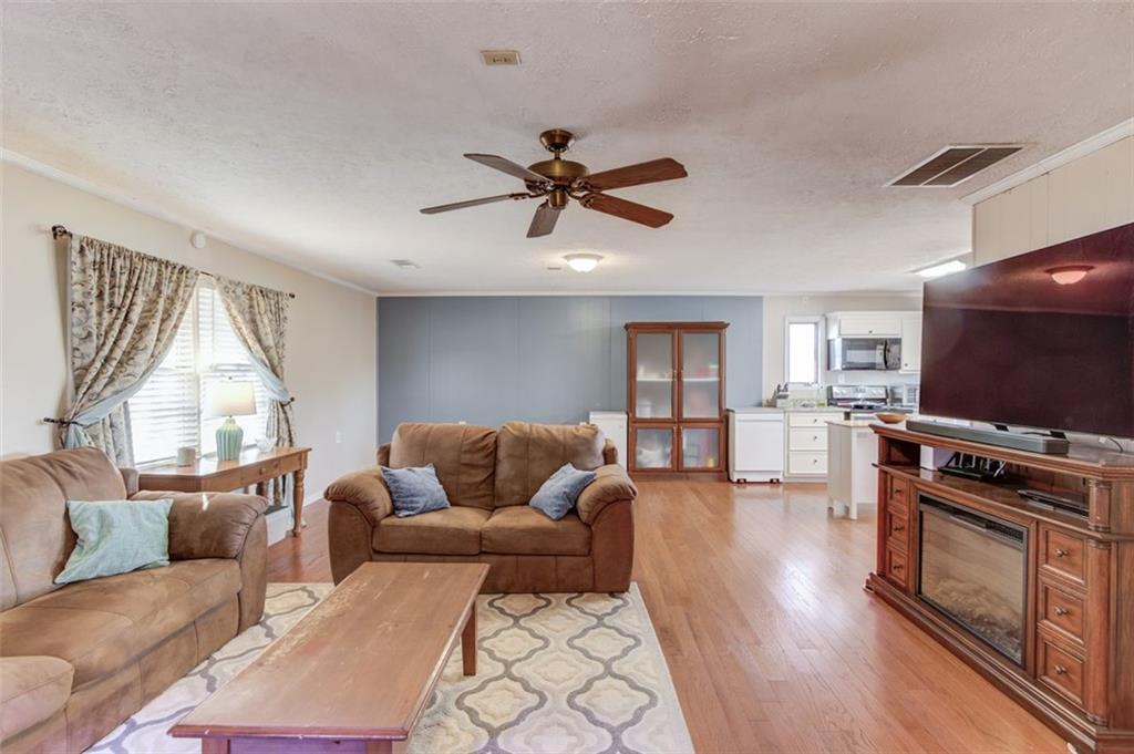 4404 Tanners Mill Road Braselton, GA 30517 - Photo 56 of 76 a living room with furniture a flat screen tv and a large window