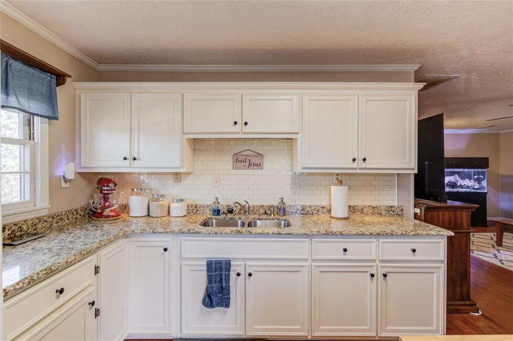 4404 Tanners Mill Road Braselton, GA 30517 - Photo 59 of 76 a kitchen with granite countertop white cabinets and white appliances