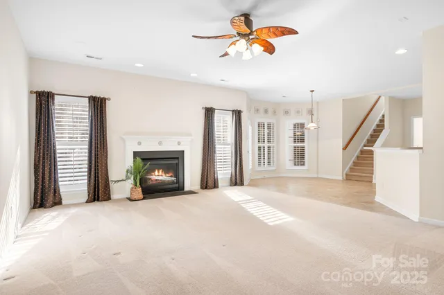 a view of an empty room with a fireplace and a window