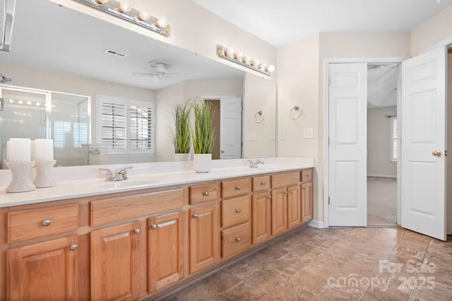a spacious bathroom with a double vanity sink a large mirror and a bathtub
