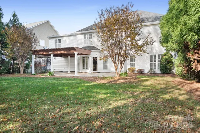 a view of a house with backyard and a tree