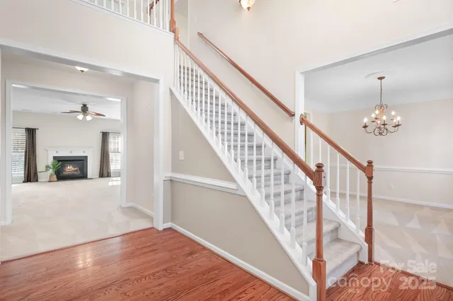 a view of staircase with wooden floor and a chandelier