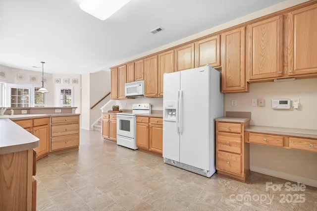 a kitchen with stainless steel appliances a refrigerator a stove a sink and cabinets