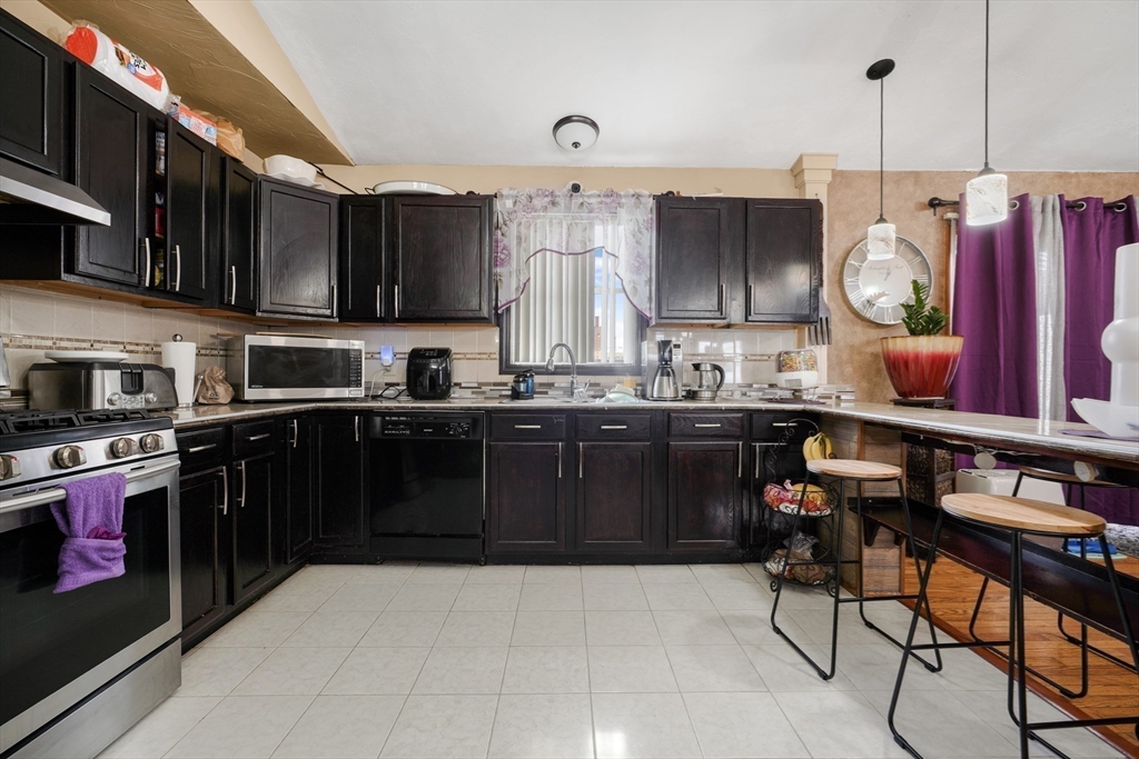 76 Price Place Fall River, MA 02724 - Photo 8 of 27 a kitchen with a sink a stove and chairs