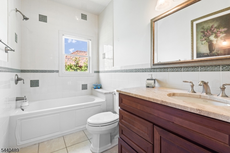 99 East Lindsley Road Cedar Grove, NJ 07009 - Photo 32 of 41 a bathroom with a granite countertop sink a toilet and a bathtub