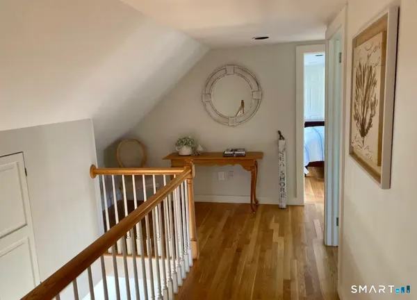 a view of a hallway with wooden floor and door