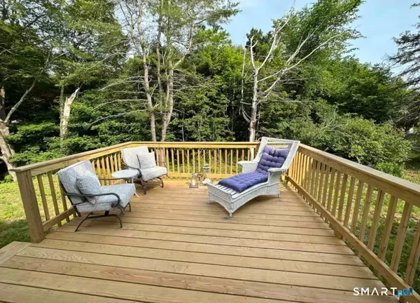 a view of deck with two chairs and wooden fence