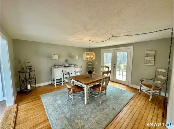 a dining room with wooden floor and window