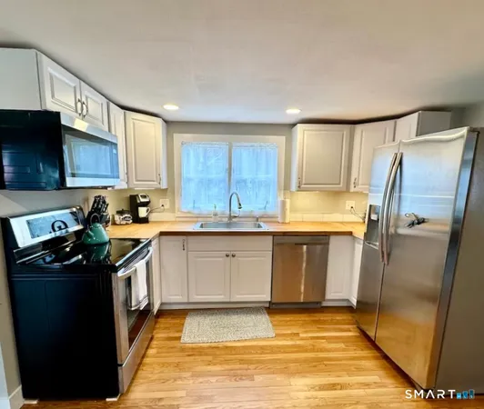 a kitchen with stainless steel appliances granite countertop a refrigerator stove top oven a sink and dishwasher