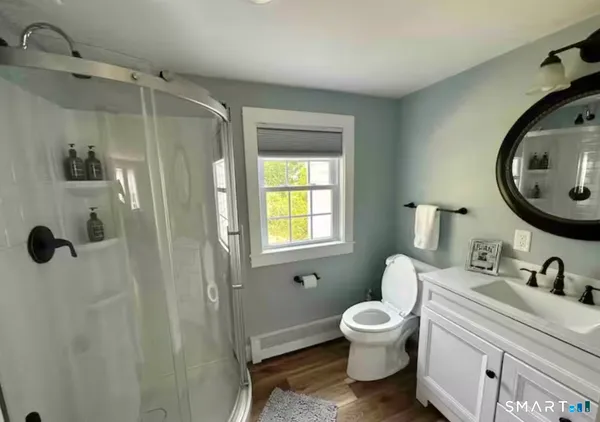a bathroom with a toilet sink a mirror and shower