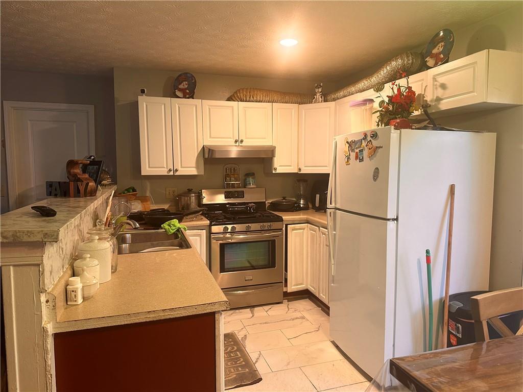 1637 Roman Point Drive Norcross, GA 30093 - Photo 8 of 21 a kitchen with a refrigerator a stove top oven a sink and dishwasher