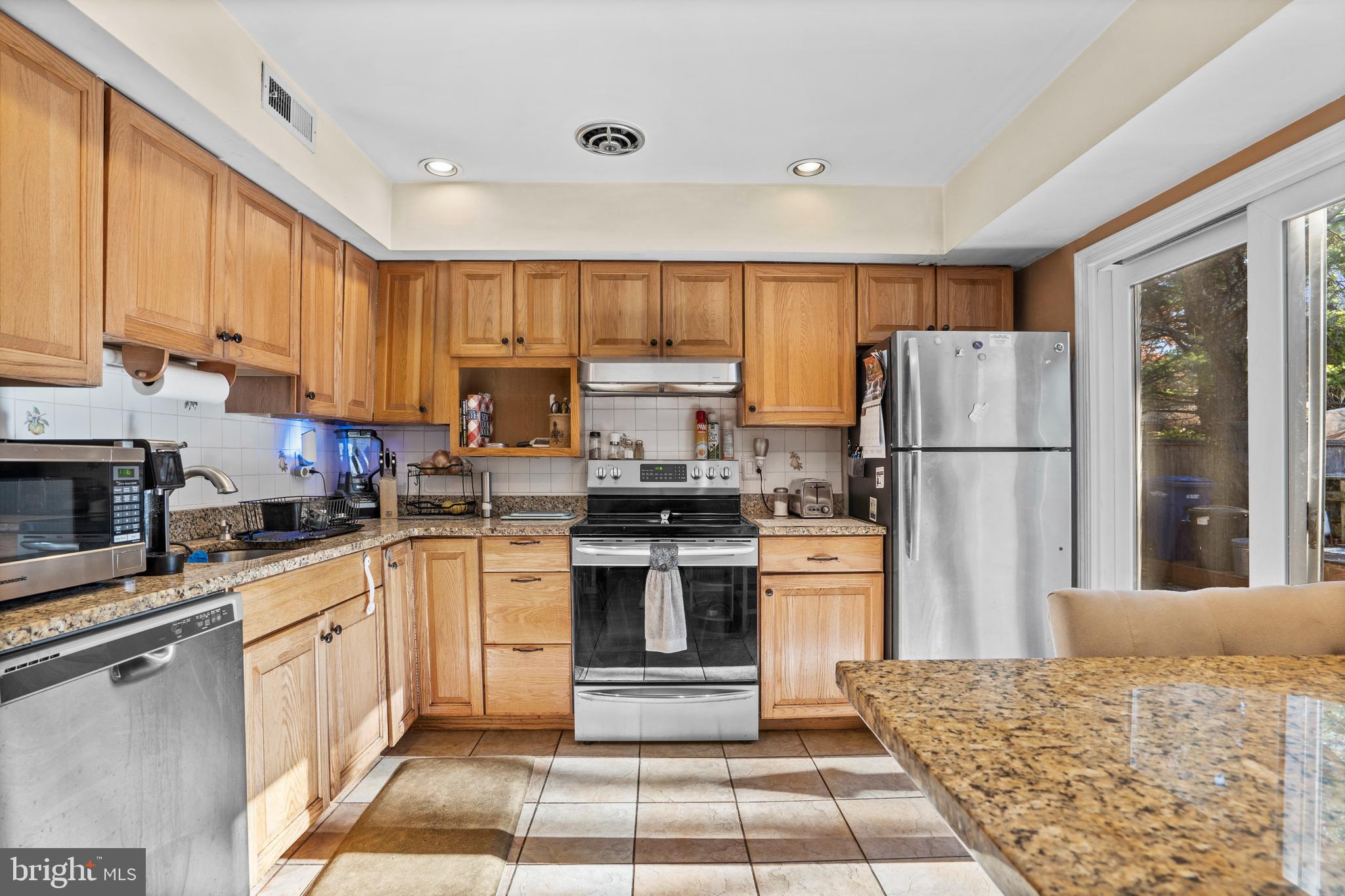 18 Essex Lane Langhorne, PA 19047 - Photo 11 of 50 a kitchen with a refrigerator a stove top oven a sink and cabinets