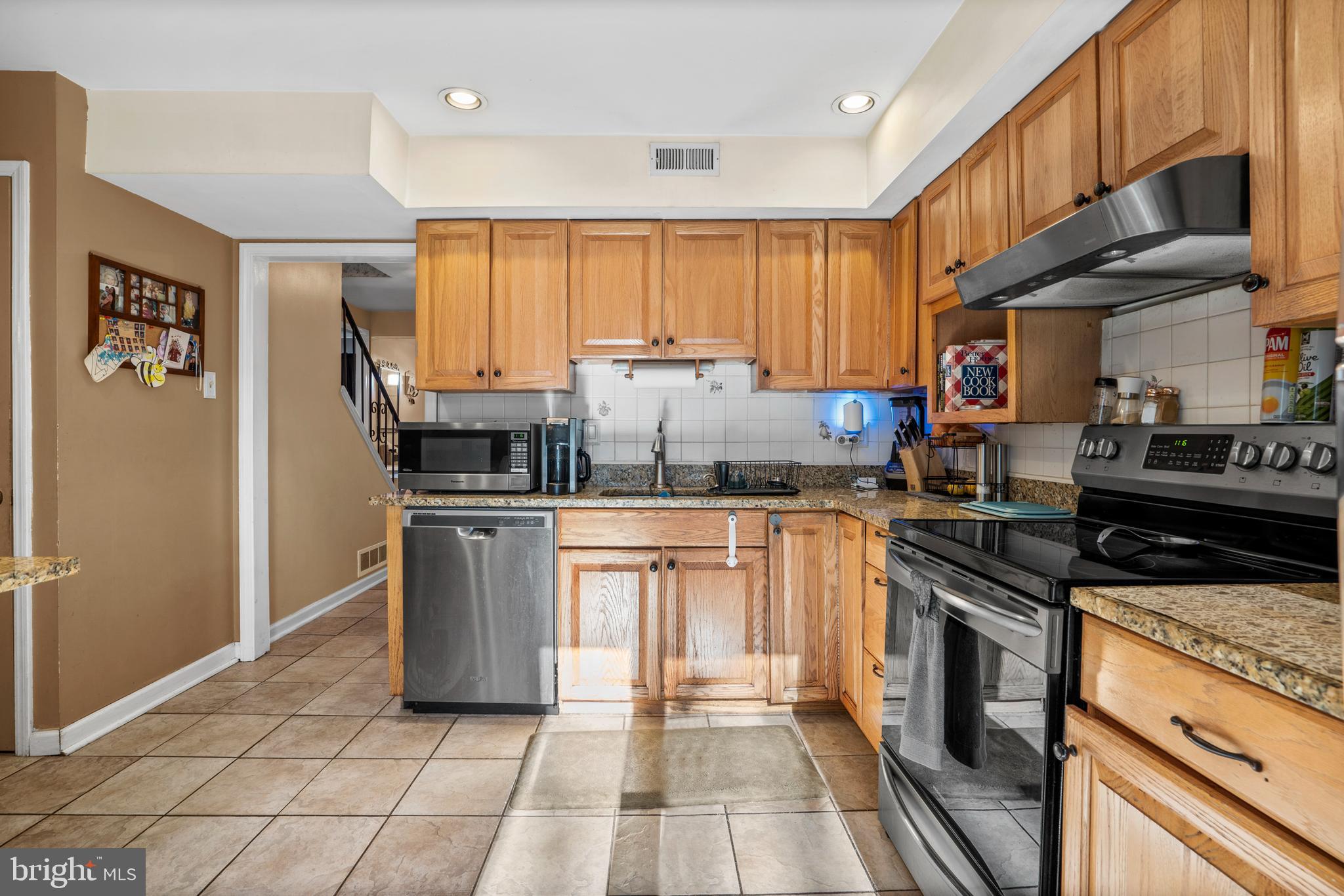 18 Essex Lane Langhorne, PA 19047 - Photo 12 of 50 a kitchen with stainless steel appliances granite countertop a stove a sink and a refrigerator