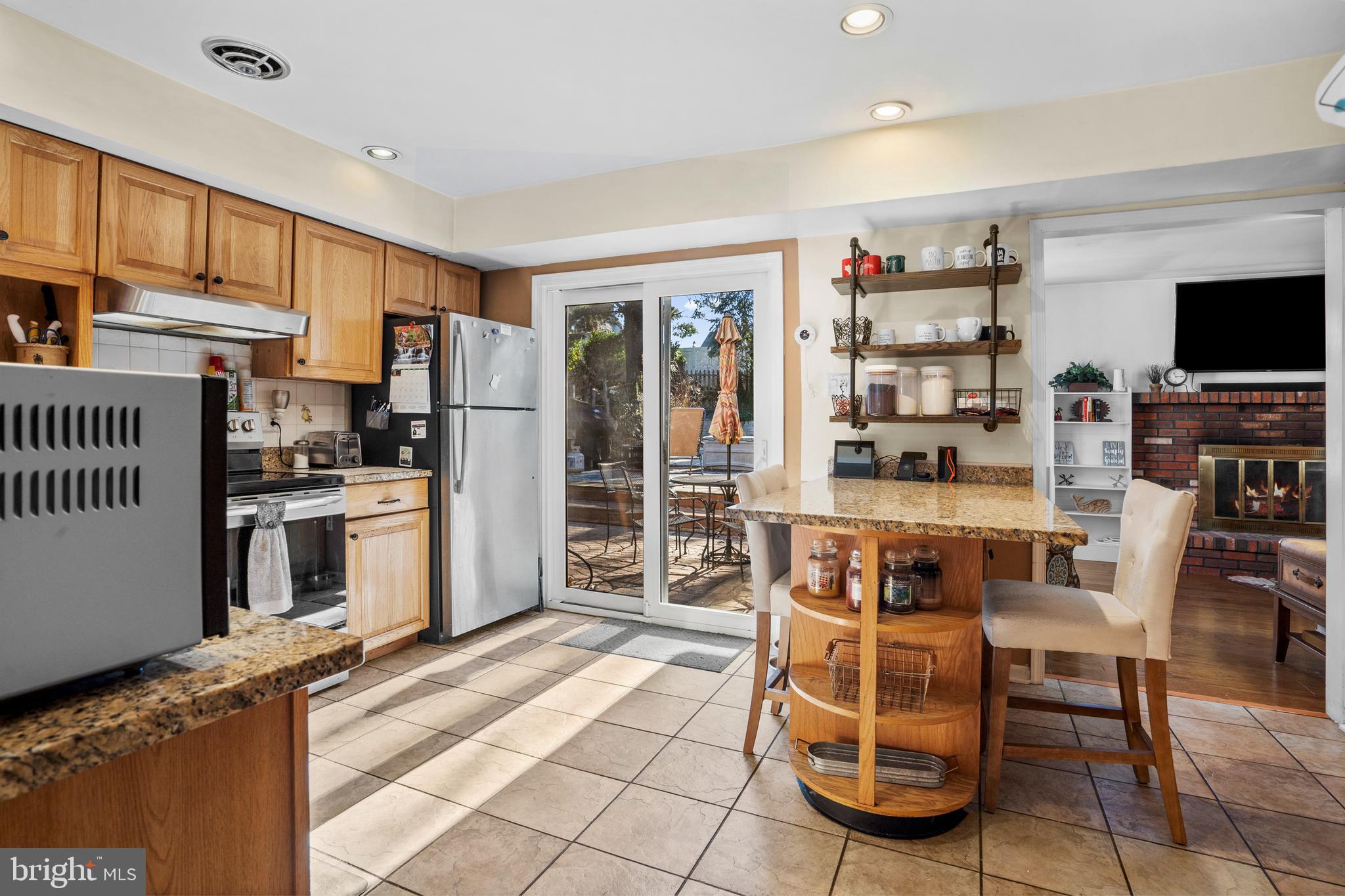 18 Essex Lane Langhorne, PA 19047 - Photo 13 of 50 a kitchen with stainless steel appliances granite countertop a stove top oven a sink a dining table and chairs