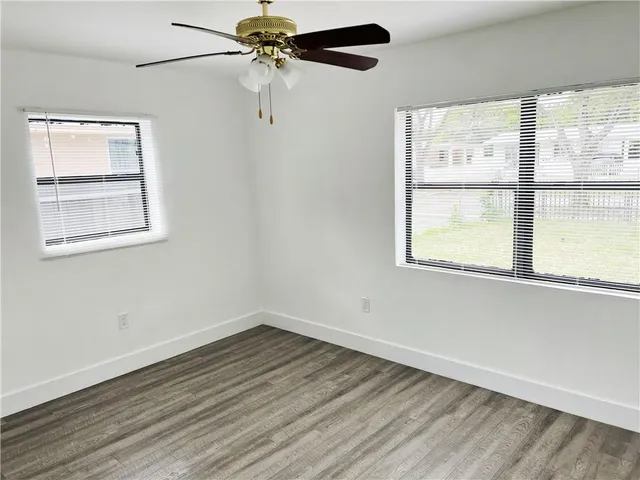 a view of a room with wooden floor and windows