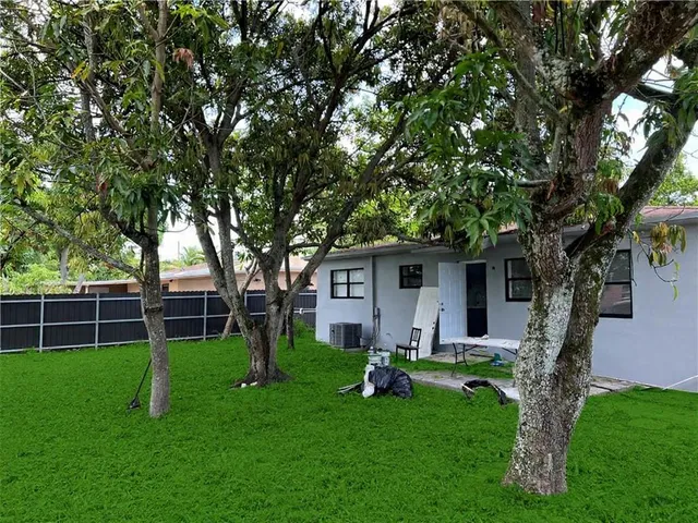 a front view of house with a garden and trees