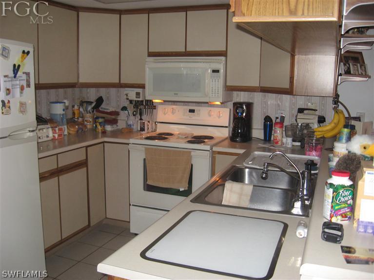 17485 Braddock Road Fort Myers, FL 33967 - Photo 4 of 11 a kitchen with a sink a stove and cabinets
