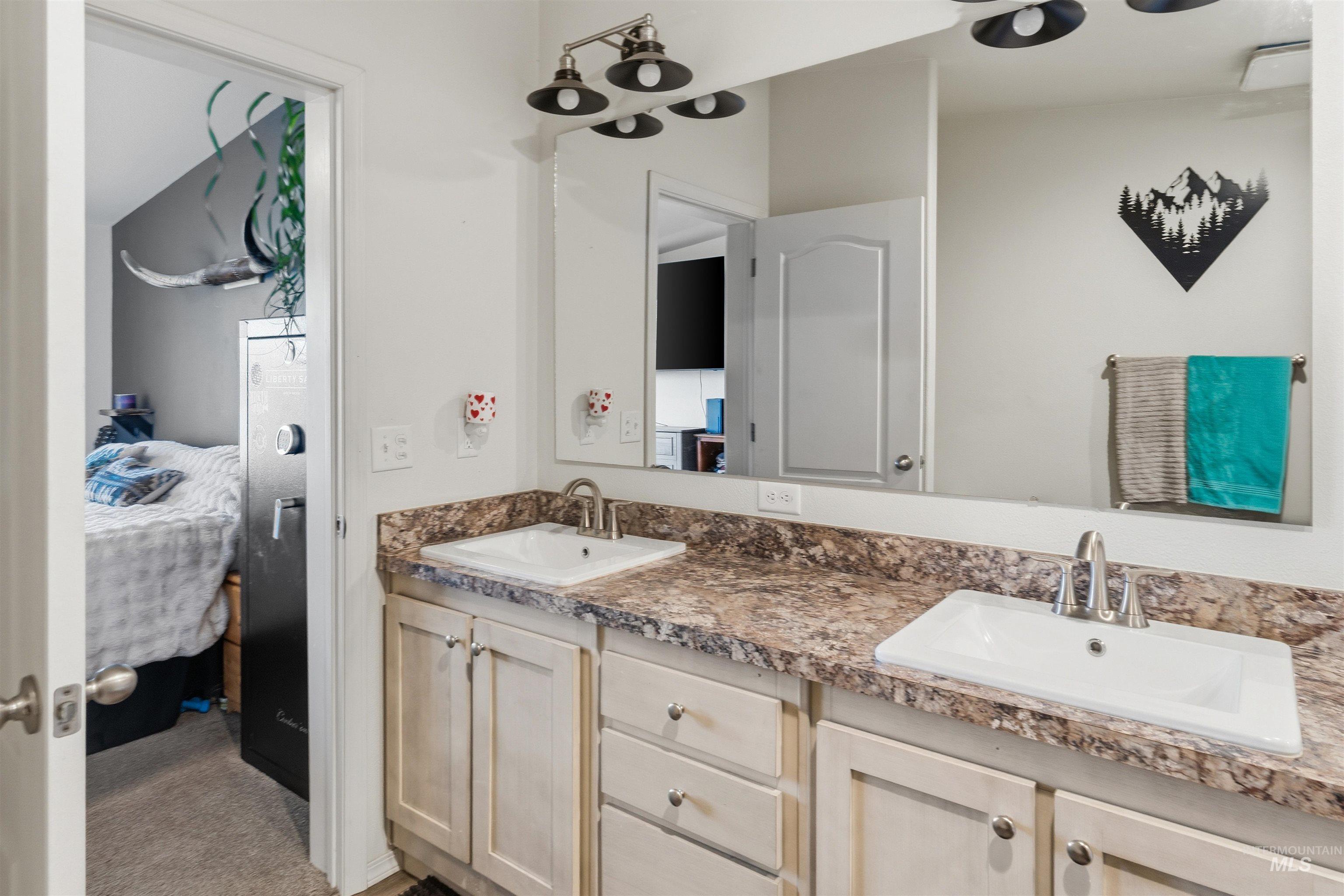 302 3rd Avenue Craigmont, ID 83523 - Photo 14 of 31 Double vanity with integrated sinks, granite-look countertop, and light-toned cabinetry