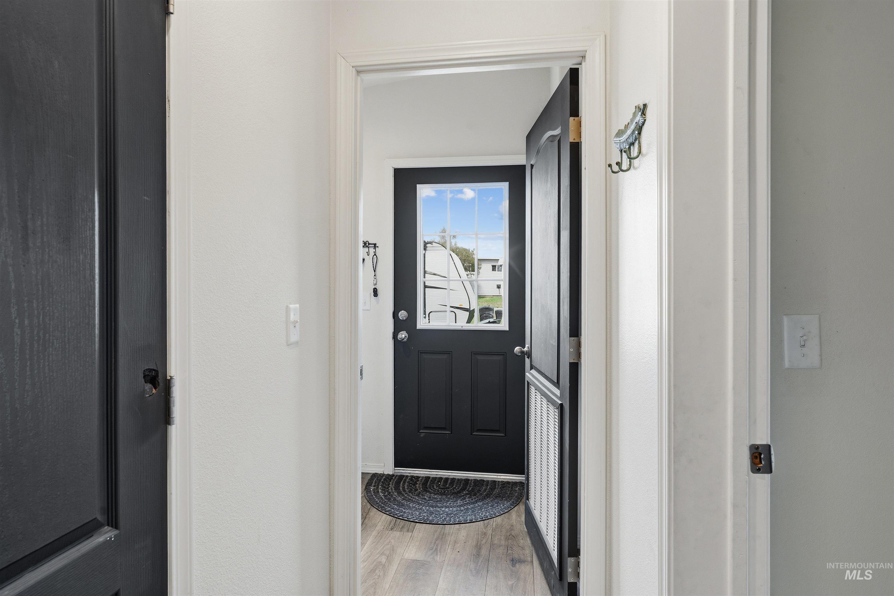 302 3rd Avenue Craigmont, ID 83523 - Photo 18 of 31 Entryway featuring a black paneled door with an upper glass pane, light wood-finish flooring, and white interior walls