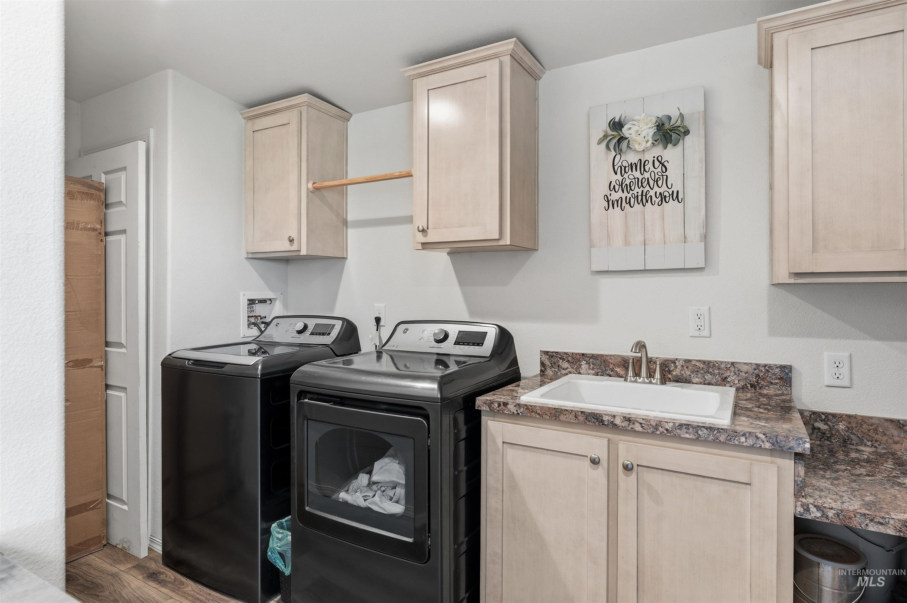 302 3rd Avenue Craigmont, ID 83523 - Photo 19 of 31 Dedicated laundry area featuring wood-finish flooring, light cabinetry, a built-in utility sink, and a countertop