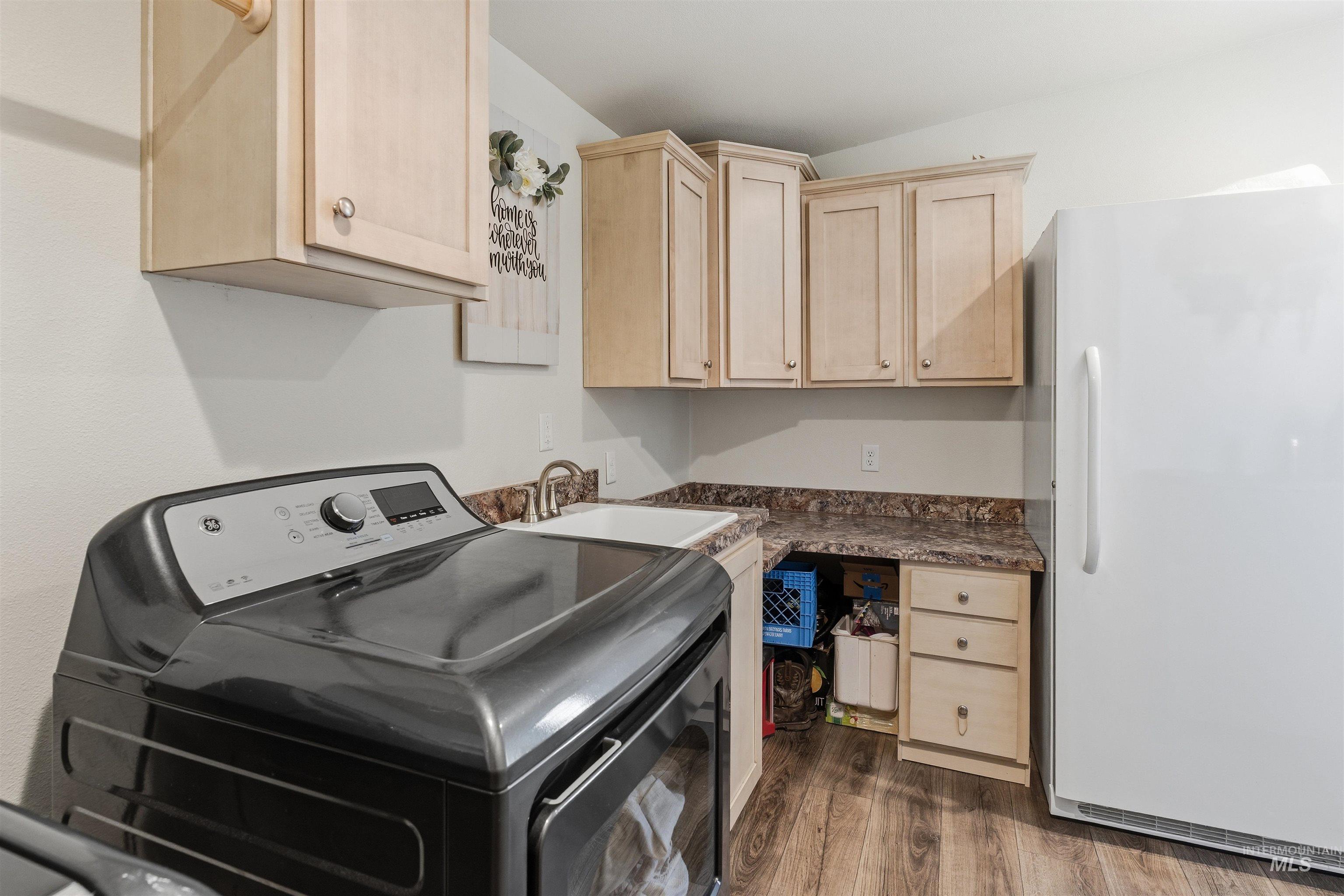 302 3rd Avenue Craigmont, ID 83523 - Photo 20 of 31 Utility space featuring wood-finish flooring, light-toned cabinetry, a built-in sink with a chrome faucet, and ample counter space