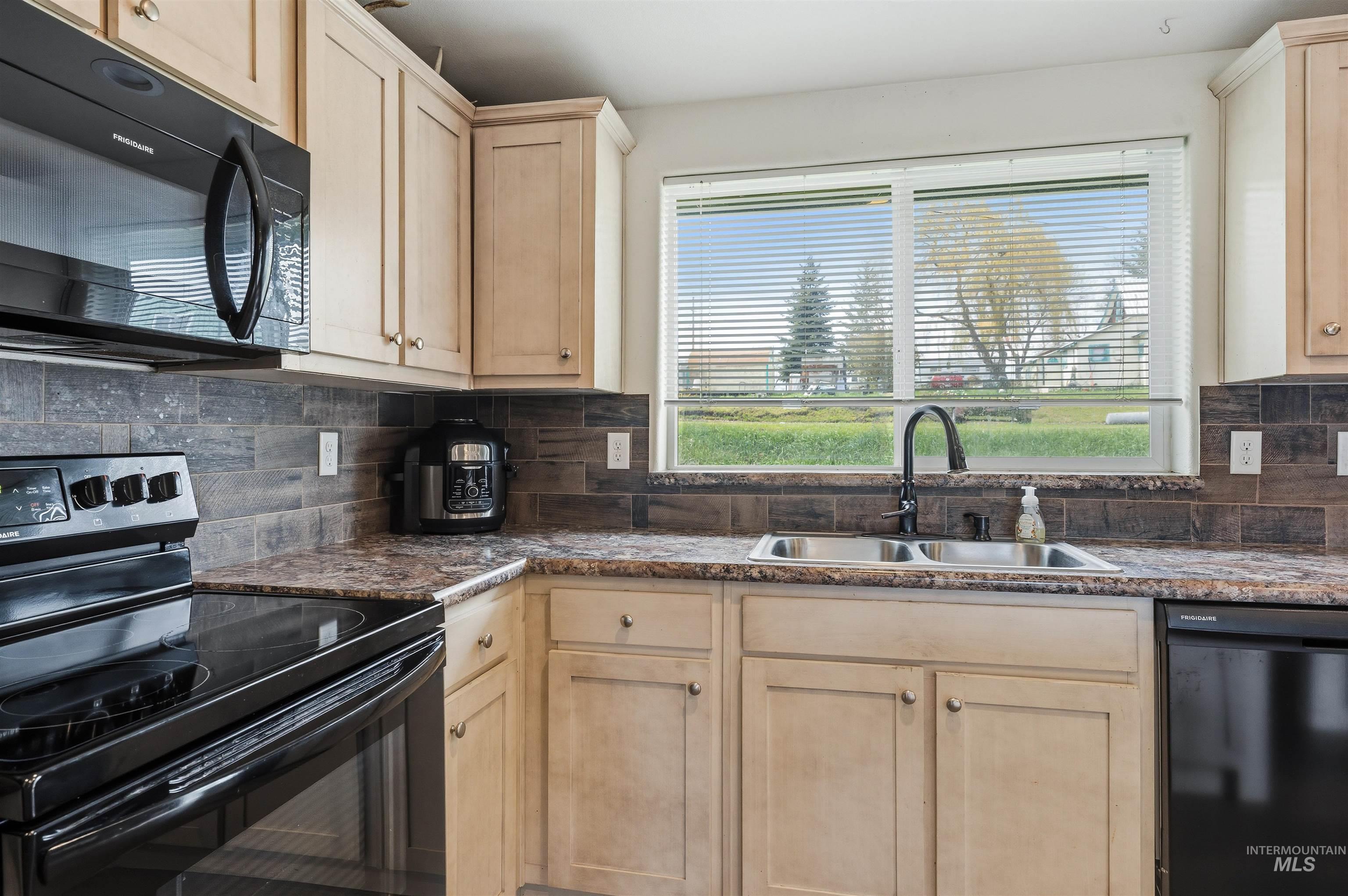 302 3rd Avenue Craigmont, ID 83523 - Photo 24 of 31 Kitchen featuring light wood cabinetry, stone-look countertops, and a tile backsplash